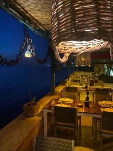 un comedor con mesas y sillas y una lámpara de araña en Halat sailing club Guest house en Ad Dawwārah