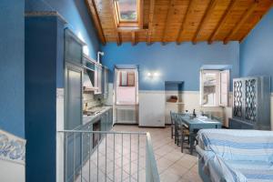 uma cozinha e sala de jantar com paredes azuis e uma mesa em Varenna Boulevard em Varenna