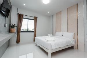a white bedroom with a bed and a tv at Get Sleep @ท่าศาลา in Ban Pho Tai