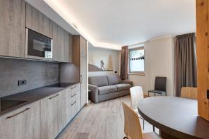 a kitchen and living room with a table and a couch at Wood Mountain Planet Suite House in Livigno