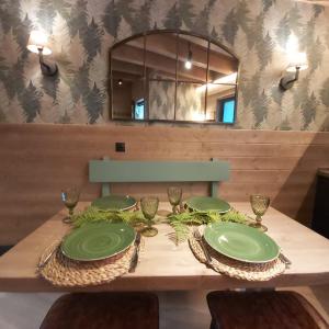 una mesa de comedor con platos verdes. en Casa con jardín Sallent en Sallent de Gállego
