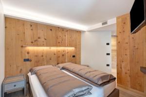 a bed in a room with wood paneling at Wood Mountain Planet Suite House in Livigno