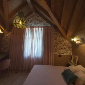 a bedroom with a bed and a window and a chandelier at Casa con jardín Sallent in Sallent de Gállego