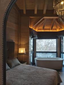 - une chambre avec un lit et une baignoire dans l'établissement Casa con jardín Sallent, à Sallent de Gállego