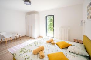 1 dormitorio blanco con 1 cama grande con almohadas amarillas en Apartment MOUNTAIN PEARL Golte, en Mozirje