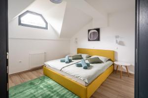 1 dormitorio con cama amarilla y alfombra verde en Apartment MOUNTAIN PEARL Golte, en Mozirje