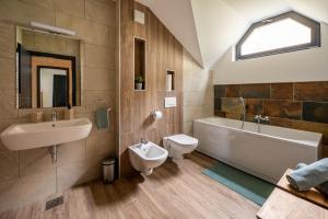 Un baño con lavabo, bañera e inodoro. en Apartment MOUNTAIN PEARL Golte, en Mozirje