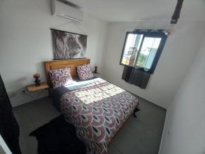 Schlafzimmer mit einem Bett und einem Fenster in der Unterkunft Maison Job in Saint-Louis