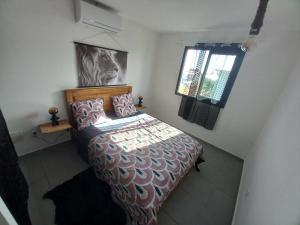 a bedroom with a bed and a window at Maison Job in Saint-Louis