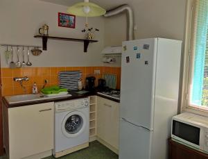 a kitchen with a white refrigerator and a washing machine at Ta Maria in Céret