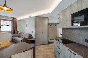 una cucina e un soggiorno con un divano e un tavolo di Ice Mountain Planet Suite House a Livigno