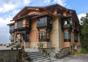 a large house with a balcony and stairs at The Chumbi Mountain Retreat & Spa in Pelling