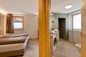 uma casa de banho com uma cama, um lavatório e uma máquina de lavar roupa em Rock Mountain Planet Suite House em Livigno