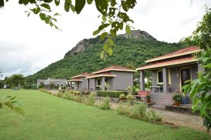 a row of houses with a mountain in the background at Eco Adventure Resorts Khhairabera in Bāghmundi