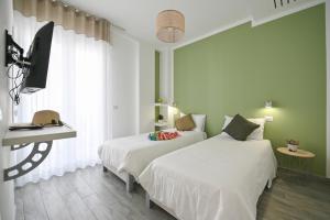 um quarto com 2 camas, uma secretária e uma janela em Dimora del Corso - Rooms em Mattinata