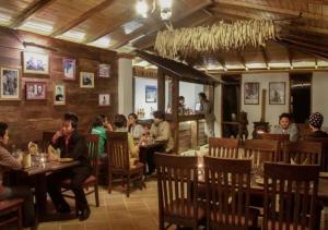 a group of people sitting at tables in a restaurant at The Chumbi Mountain Retreat & Spa in Pelling