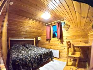 a bedroom with a bed in a wooden cabin at Arctic-maja A in Kittilä