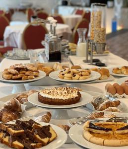 une table garnie de assiettes de pâtisseries et de gâteaux dans l'établissement Aequa Hotel, à Vico Equense