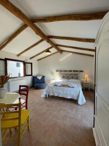 Schlafzimmer mit einem Bett, einem Tisch und Stühlen in der Unterkunft Panoramic Loft con uso cucina,Casa Placida - Ammentos in Posada