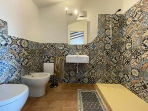 ein Badezimmer mit einem WC, einem Waschbecken und einer Badewanne in der Unterkunft Panoramic Loft con uso cucina,Casa Placida - Ammentos in Posada