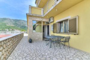 a patio with a table and chairs outside of a building at Apartments Zora in Senj