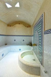a large bathroom with a tub and a tiled floor at Villa du Cedre in Marrakech