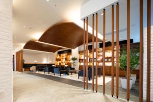 a lobby of a building with chairs and tables at Via Inn Prime Hiroshima Shinkansenguchi in Hiroshima