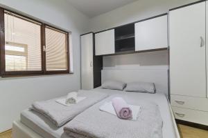a bedroom with two beds with towels on them at Apartments Zora in Senj