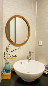 a bathroom with a white sink and a mirror at Lacovy Home Hội An in Hoi An