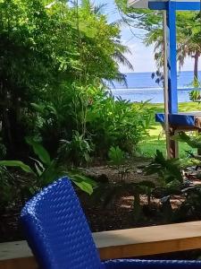 Are Tamareni 2BR Beach Cottage or River Studio في أفاروا: كرسي ازرق جالس امام منظر المحيط