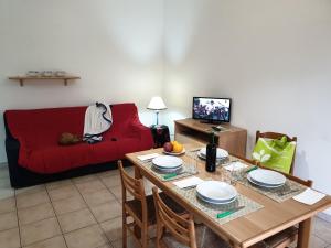 un soggiorno con un tavolo e un divano rosso di Residence Adriatico a Silvi Marina