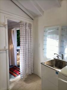 a kitchen with a sink and a door to a yard at Are Tamareni River Studio in Avarua +30 photos