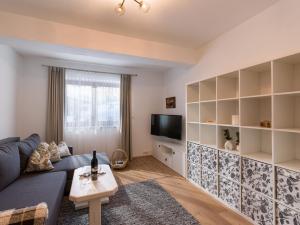 uma sala de estar com um sofá azul e uma televisão em Haus TIROL em Thiersee