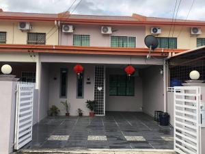a house with white doors and red flowers on it at ANG LEE HOLIDAY HOME 1 in Semporna