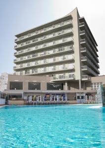 a large building with a swimming pool in the middle of it at Hotel Las Gaviotas in La Manga del Mar Menor