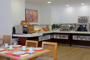 a kitchen with a table and chairs and a kitchen with a counter at Hotel Apartamentos Pyr Fuengirola in Fuengirola +88 photos