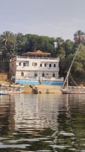 Un grand bateau blanc est amarré dans l'eau. dans l'établissement ABAZIDO Nubian Guest House, à Assouan