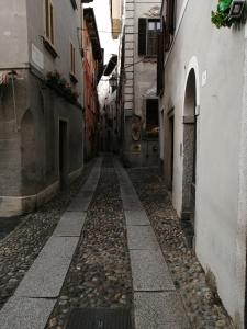 un callejón en un viejo pueblo con edificios en Il Sasso appartamento, en Orta San Giulio