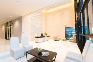 a living room with white chairs and a table at Sugar Palm Residence in Phuket