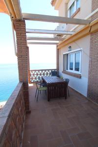 a patio with a table and chairs on a brick wall at Casa La Rijana 8 in Almuñécar
