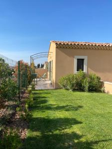 a yard of a house with a grassy yard at Le petit Mazet du Domaine avec sa piscine in Saint-Rémy-de-Provence