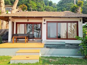 ein kleines Haus mit einer Terrasse und einem Tisch in der Unterkunft Siam Bay Resort in Ko Chang