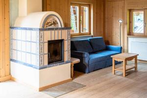 a living room with a fireplace and a blue couch at Ciesa Al Drago in Rocca Pietore