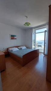 a bedroom with a large bed with a view of the ocean at Apartmani Matea in Zaton