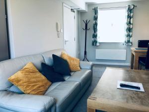 uma sala de estar com um sofá e uma mesa em Two Warehouse Apartments em Ulverston