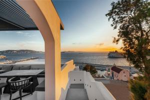 a balcony with a view of the ocean and a cruise ship at Tagoo Black Mykonos in Mýkonos City