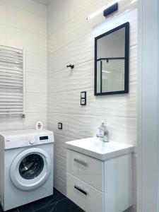 uma casa de banho branca com uma máquina de lavar roupa e um lavatório em Ach, To Tu- Apartament Łańcut em Lańcut