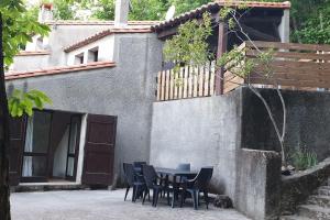 a table and chairs in front of a building at Le Gîte du Truel in Mars