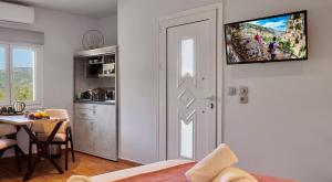 a kitchen and dining room with a television on the wall at Apartments Gonies - Artemis in Goníai