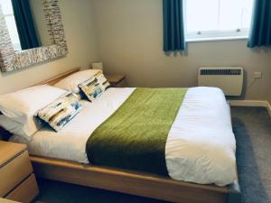 a bedroom with a large bed with two pillows at Two Warehouse Apartments in Ulverston